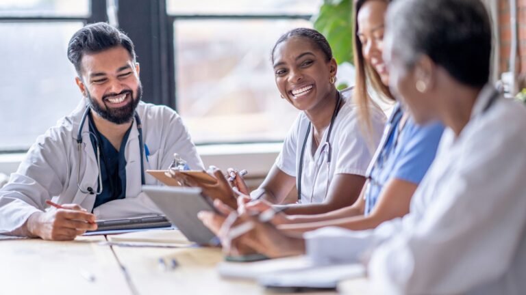 Profesionales de salud reunidos, sonrientes durante una capacitación